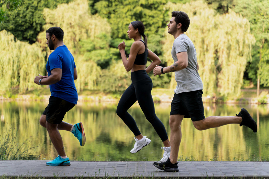 Three people running on the footpath near the lake